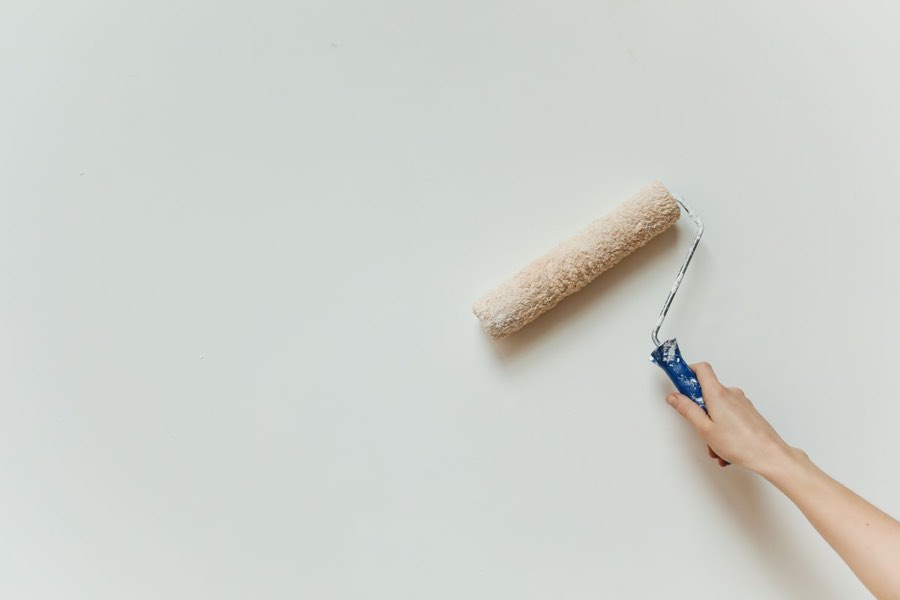 Farbroller streicht eine helle Wand, Beispielfoto